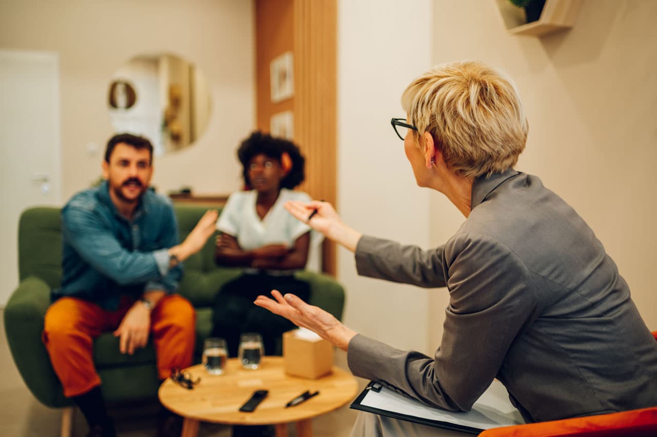 Advisor leading a risk conversation with a couple during a financial planning meeting focused on wealth management and long-term decision-making.